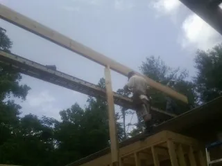 Carpenter setting a ridge beam over a new addition frame — Ice Dam Removal by Roofing Brothers in Ruskin