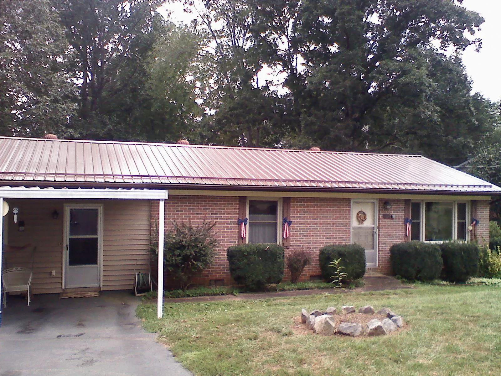 Bronze metal roof and carport on a brick ranch home — Roof Repair work by our crew in Ruskin